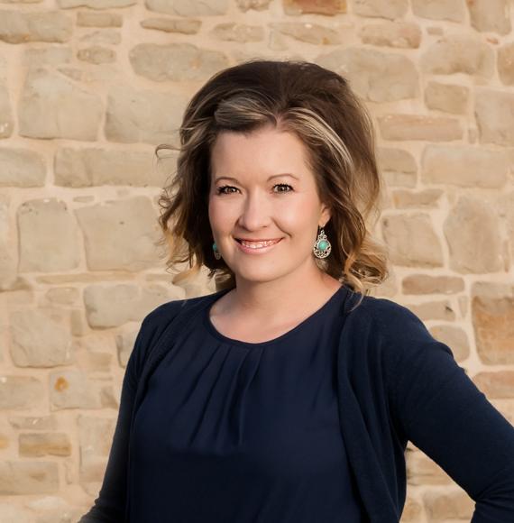 misty berg standing by a stone wall smiling